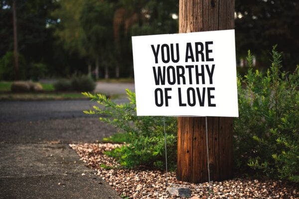 Jesteś Godzien Miłości Na Brązowym Drewnianym Słupku. Zdanie, które pomaga budować poczucie własnej wartości