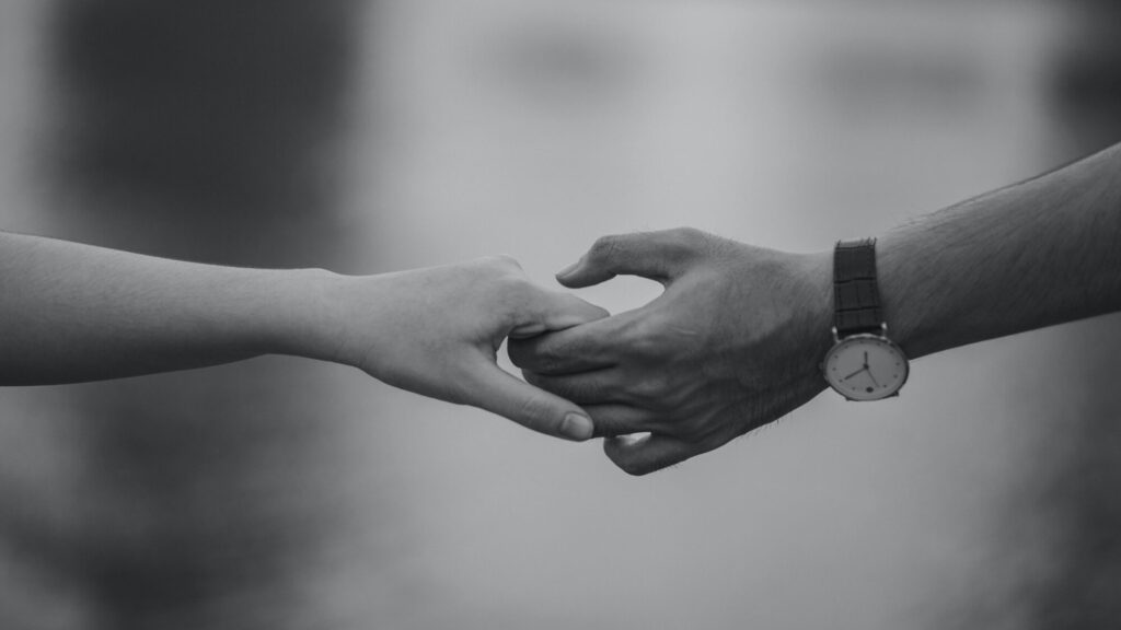 Dwie ręce zakochanych, którzy zastanawiają się jak uratować związek, który przechodzi kryzys