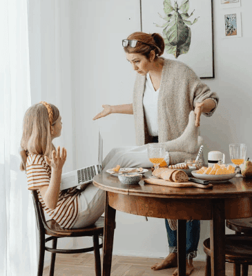 zaburzenia zachowania, Na zdjęciu widzimy młodą osobę siedzącą przy stole, która korzysta z laptopa, a obok niej znajduje się dorosła osoba, najprawdopodobniej matka, która gestykuluje i wygląda na zdenerwowaną. Ich interakcja może wskazywać na sytuację, w której pojawiają się pierwsze objawy problemów wychowawczych lub zaburzeń zachowania, gdzie dorosły stara się wyjaśnić, poprawić lub zrozumieć reakcję młodzieży. Tego typu interakcje mogą być częścią prawidłowego procesu socjalizacji, jednak w przypadku zaburzeń zachowania takie sceny mogą być również sygnałem trudności w adaptacji do norm społecznych i emocjonalnych. Psycholog mógłby wskazać na zachowania, które są połowę mniejsze niż oczekiwane w danym wieku, co może sugerować problemy w rozwoju.