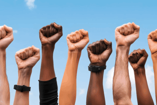 dyskryminacja, ręce w różnych kolorach skóry pokazujące gest walki, siły