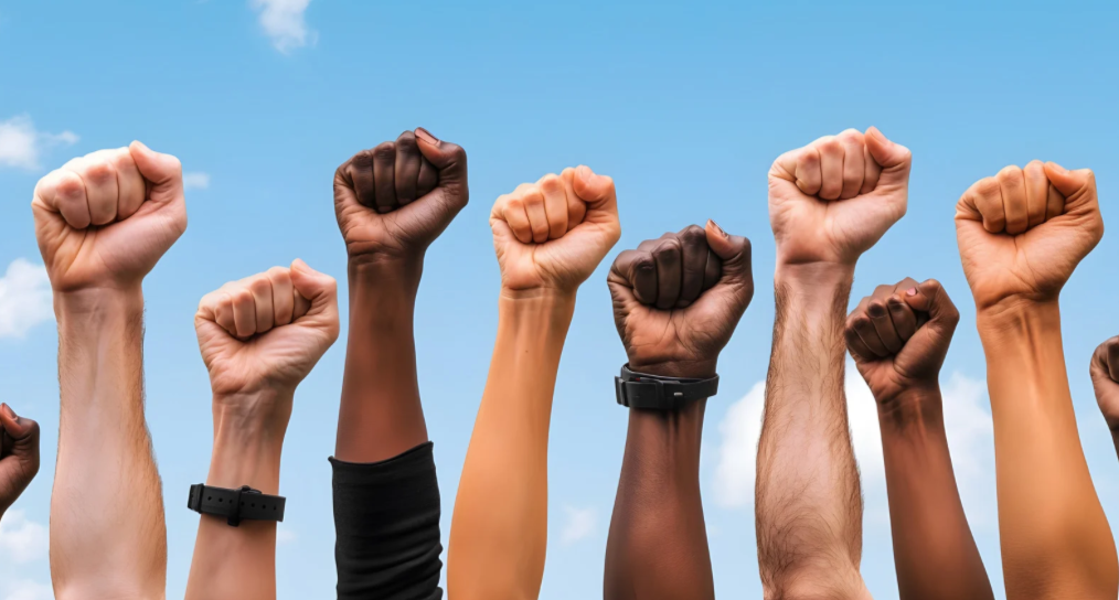 dyskryminacja, ręce w różnych kolorach skóry pokazujące gest walki, siły