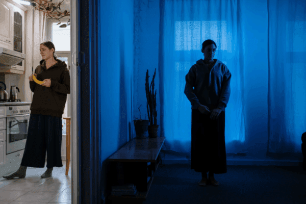 chwilowa utrata kontaktu z rzeczywistością, Na zdjęciu widać dwie kontrastowe przestrzenie: jasną kuchnię i ciemny, niebiesko oświetlony pokój. Ten kontrast może kojarzyć się z tematami, o których często mówi się w kontekście chorób psychicznych – np. przechodzeniem między różnymi stanami emocjonalnymi. Nastrój części w cieniu przywodzi na myśl sposób, w jaki w sztuce przedstawia się psychozy, tworząc atmosferę oderwania od codzienności. Ujęcie może symbolizować różne zachowania chorego ukazywane w filmie lub fotografii, a powtarzający się podział światła i cienia bywa wykorzystywany jako metafora zachowania chorego w artystycznych narracjach.