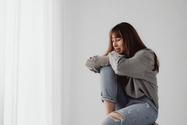 uczucie roztrzęsienia w środku, kobieta płacze w kącie