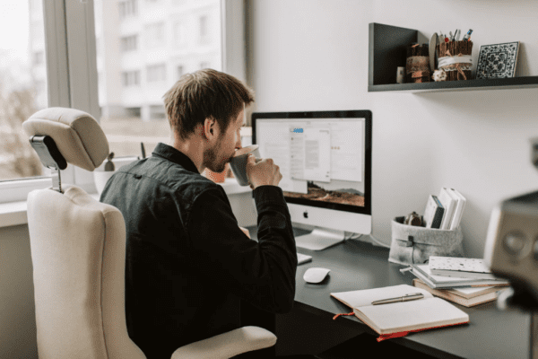 niechęć do pracy, mężczyzna pracujący w biurze, pijący kawę