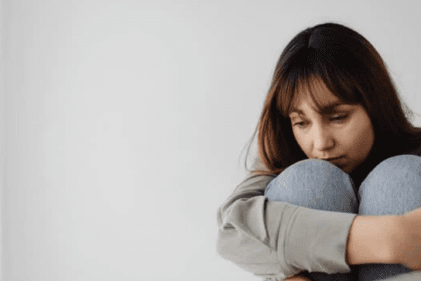 nietypowe objawy depresji, skulona siedząca kobieta