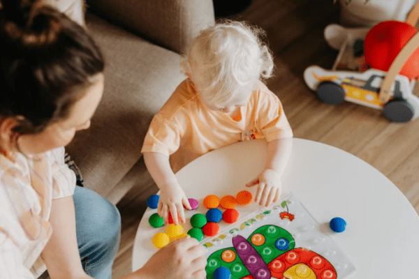 zaburzenia hiperkinetyczne, dziecko bawiące się kolorowymi klockami
