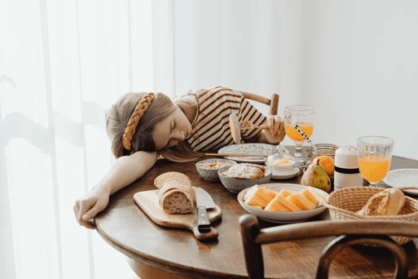 terapia zaburzeń odżywiania, dziewczyna leży na stole pełnym jedzenia