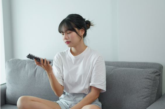 ghosting, dziewczyna siedzi na kanapie z telefonem