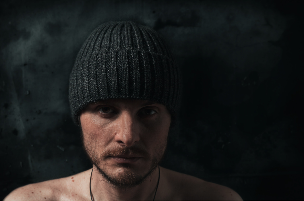 czego nie lubi psychopata, mężczyzna z poważną miną w czapce patrzący się wprost