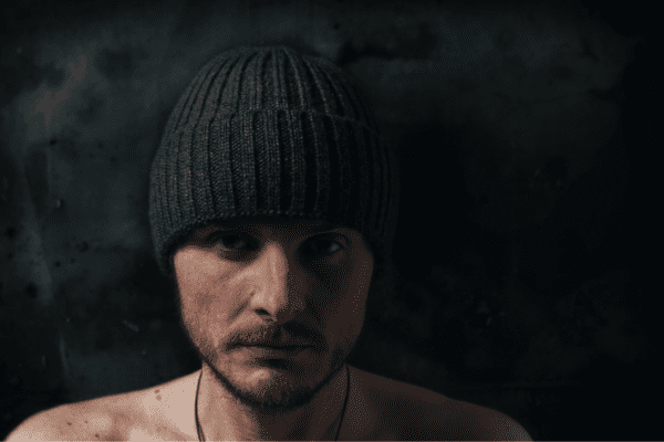 czego nie lubi psychopata, mężczyzna z poważną miną w czapce patrzący się wprost