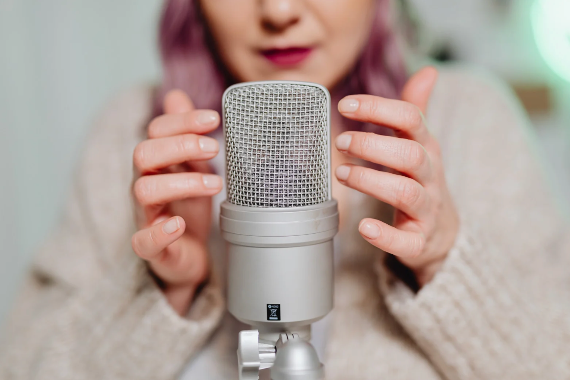 afazja ruchowa, kobieta siedząca przy mikrofonie
