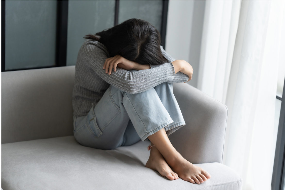  lękowo ambiwalentny styl przywiązania, kobieta siedząca skulona na łóżku