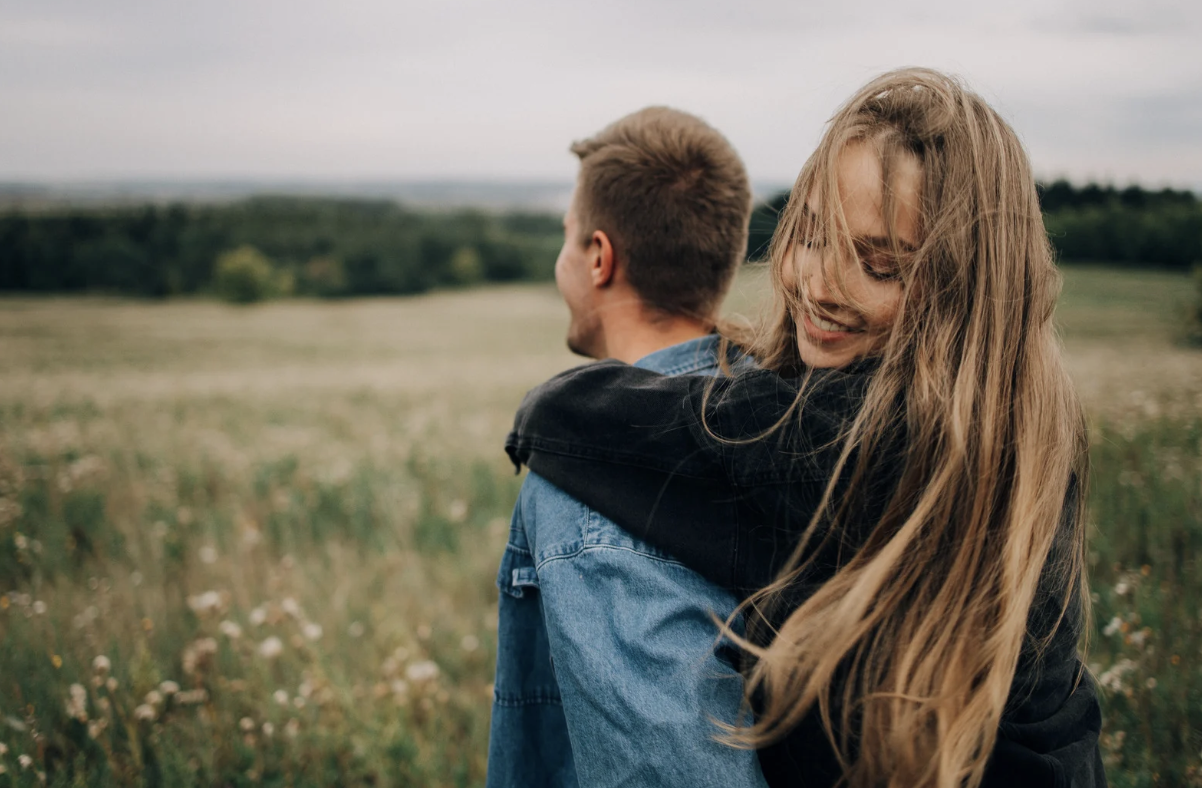 deprecjonowanie, kobieta i mężczyzna przytulający się na łące