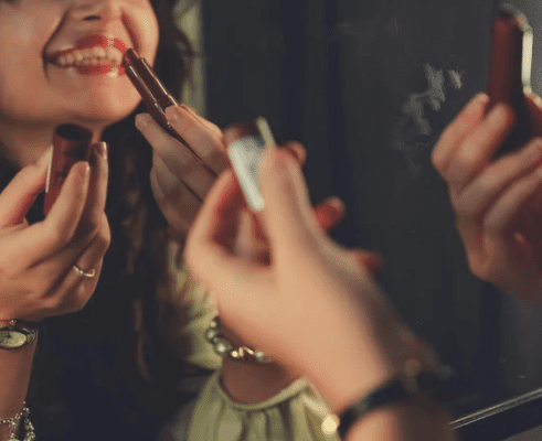 aparycja; na zdjęciu kobieta maluje usta szminką