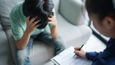 najskuteczniejsze leczenie borderline - pacjent trzyma się za głowę i siedzi na sofie u terapeuty