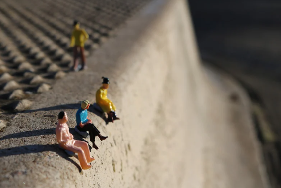 kto potrzebuje psychoterapii? miniaturki ludzi siedzą na krawędzi