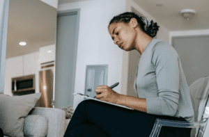 po czym poznać dobrego terapeutę, psycholog pisząca notatki w gabinecie