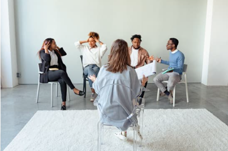 Psychoterapia indywidualna vs grupowa — co wybrać? - zdjęcie przedstawia 4 osoby na spotkaniu grupowym u psychoterapeuty