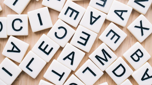 lęk przed długimi słowami, na blacie znajdują się rozsypane scrabble z literami alfabetu