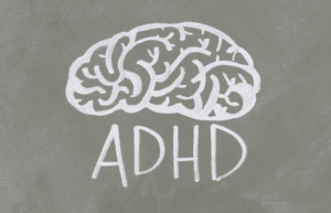 problemy z koncentracją u dorosłych - zdjęcie przedstawia napis 'ADHD' i ilustrację mózgu narysowaną kredą na tablicy