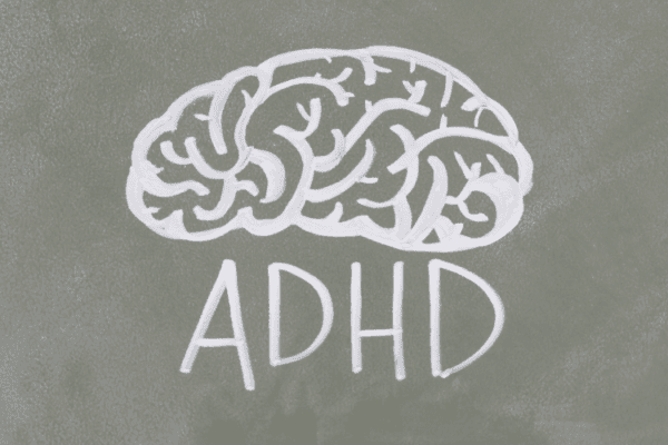 problemy z koncentracją u dorosłych - zdjęcie przedstawia napis 'ADHD' i ilustrację mózgu narysowaną kredą na tablicy